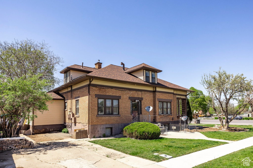 View of front of house with a front yard and a patio area