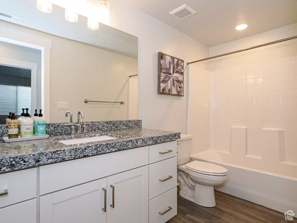 Full bathroom featuring vanity, hardwood / wood-style floors, toilet, and shower / bath combination