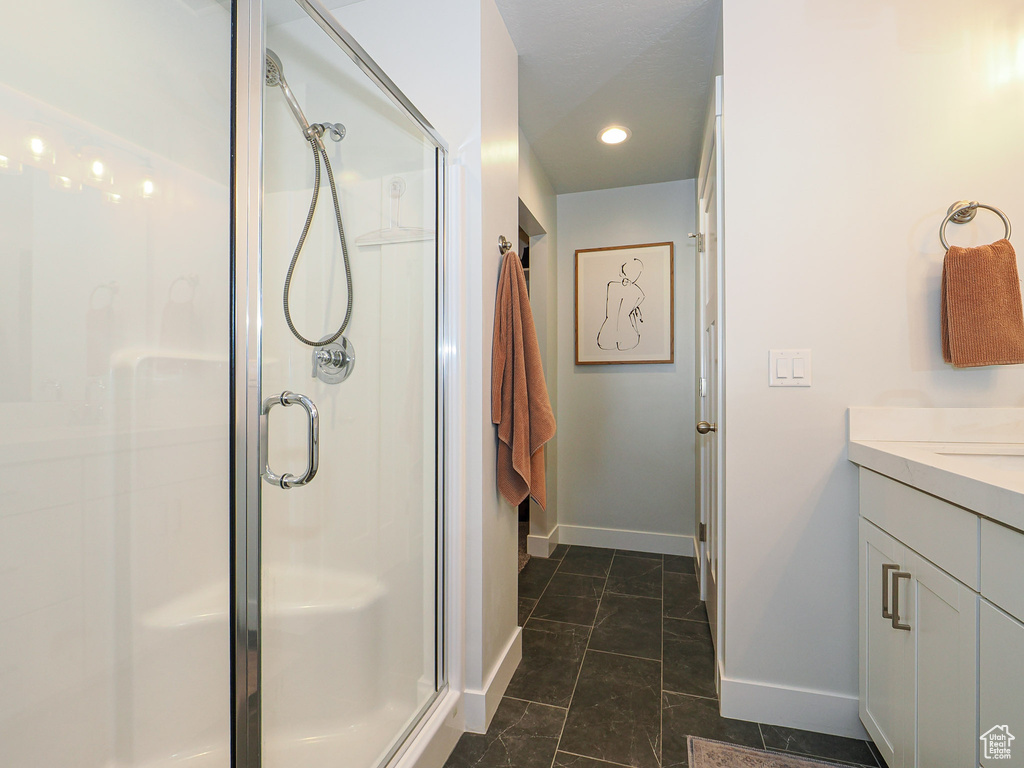 Bathroom featuring vanity and a shower with shower door