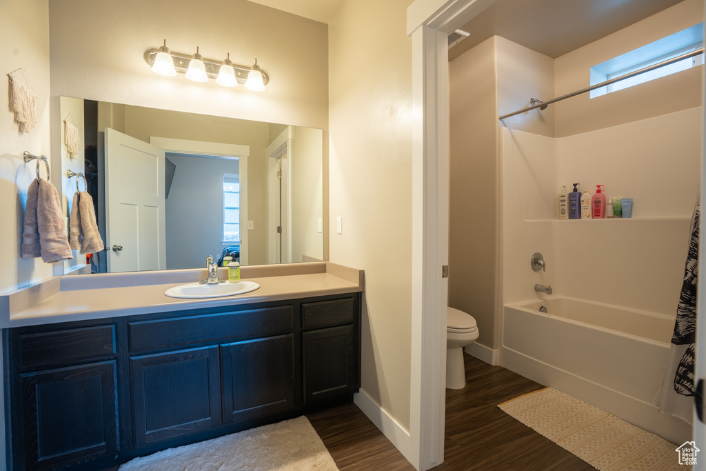 Full bathroom with shower / bathtub combination, wood-type flooring, toilet, and vanity