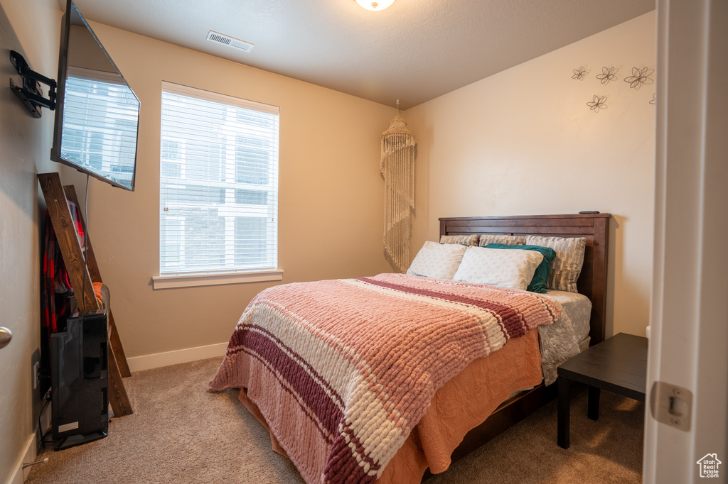 Bedroom featuring light carpet