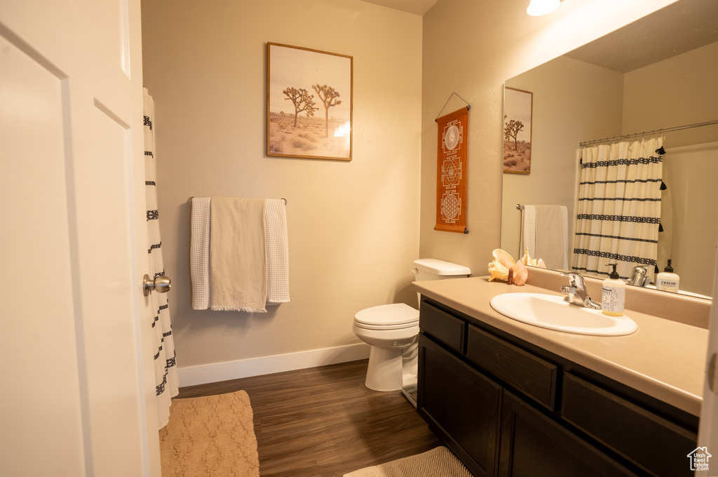 Bathroom featuring hardwood / wood-style flooring, vanity, and toilet