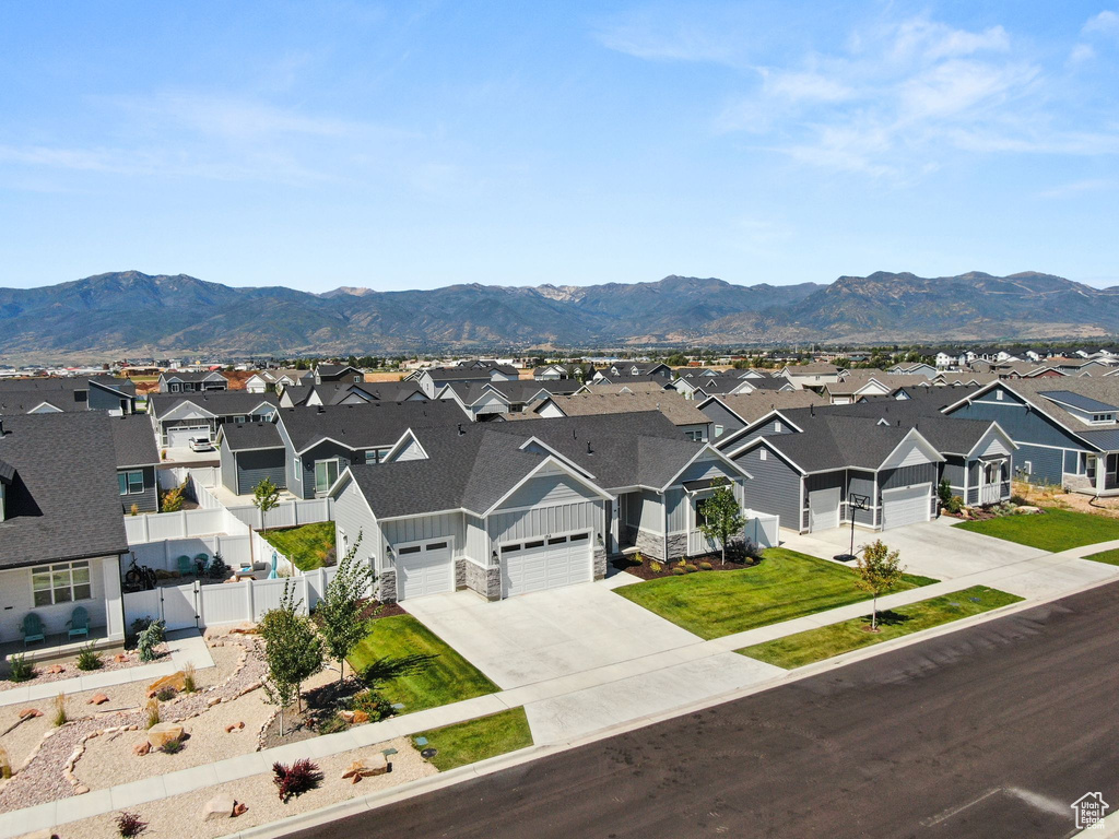 Ranch-style house featuring a garage, a mountain view, and a front lawn