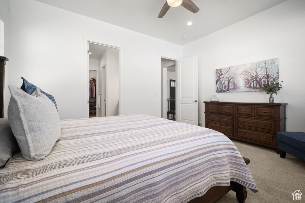 Bedroom with ceiling fan and light carpet