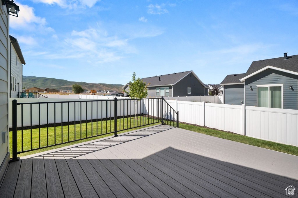 Wooden deck with a mountain view and a lawn