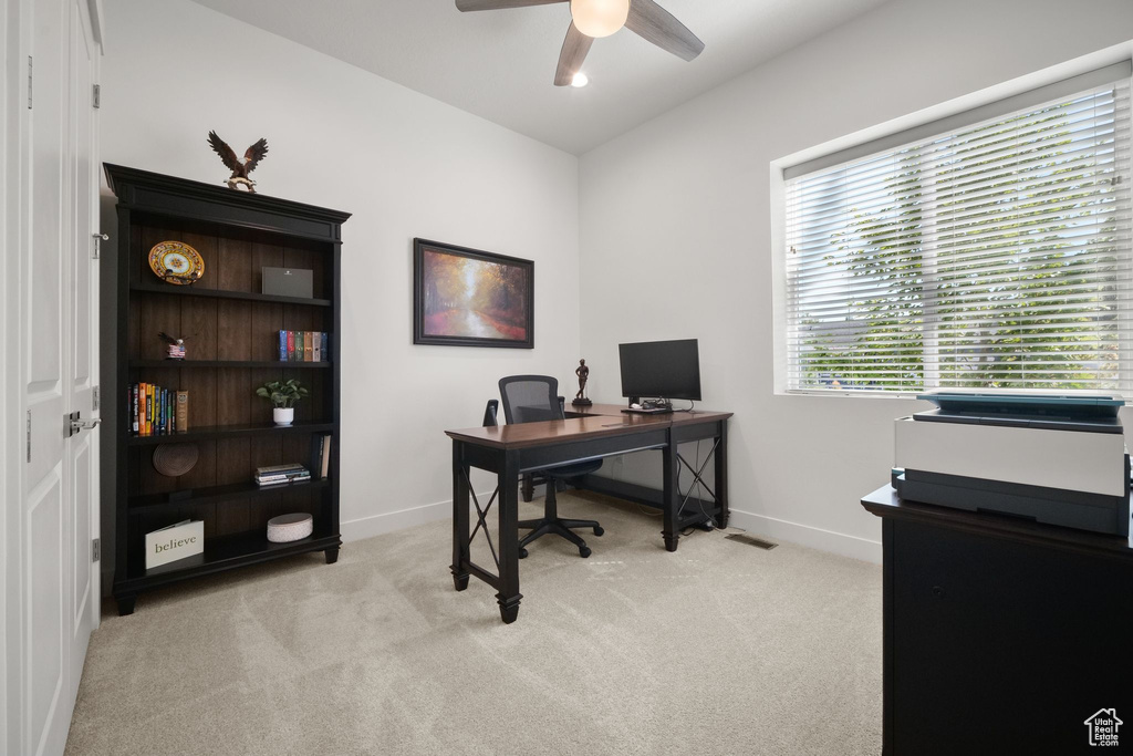 Office space with light carpet and ceiling fan