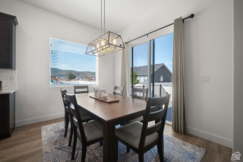 Dining area with a notable chandelier and dark hardwood / wood-style floors