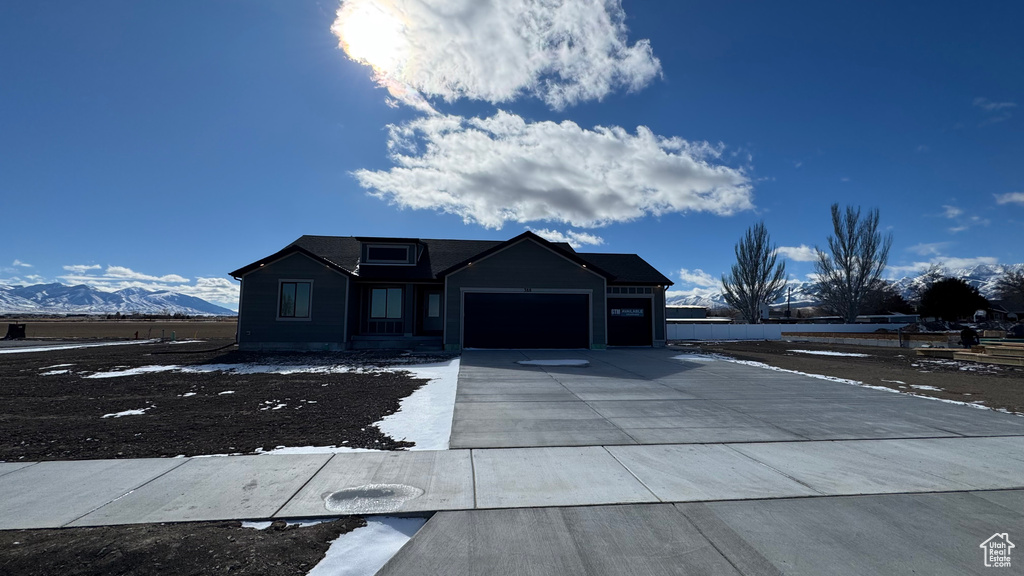 View of front of home with a garage and a mountain view