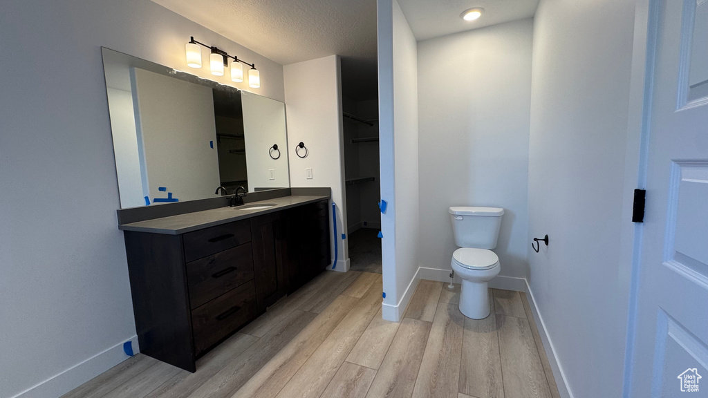 Bathroom featuring wood-type flooring, vanity, and toilet