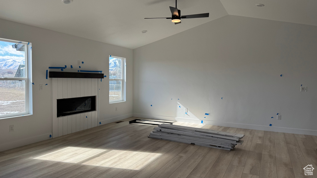 Unfurnished living room featuring lofted ceiling, light hardwood / wood-style flooring, and ceiling fan