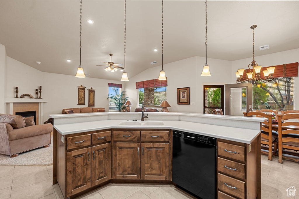 Kitchen with decorative light fixtures, dishwasher, sink, and a center island with sink