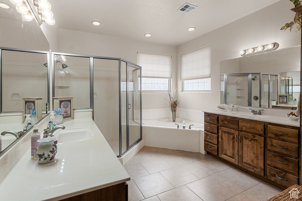 Bathroom with tile patterned flooring, vanity, and separate shower and tub