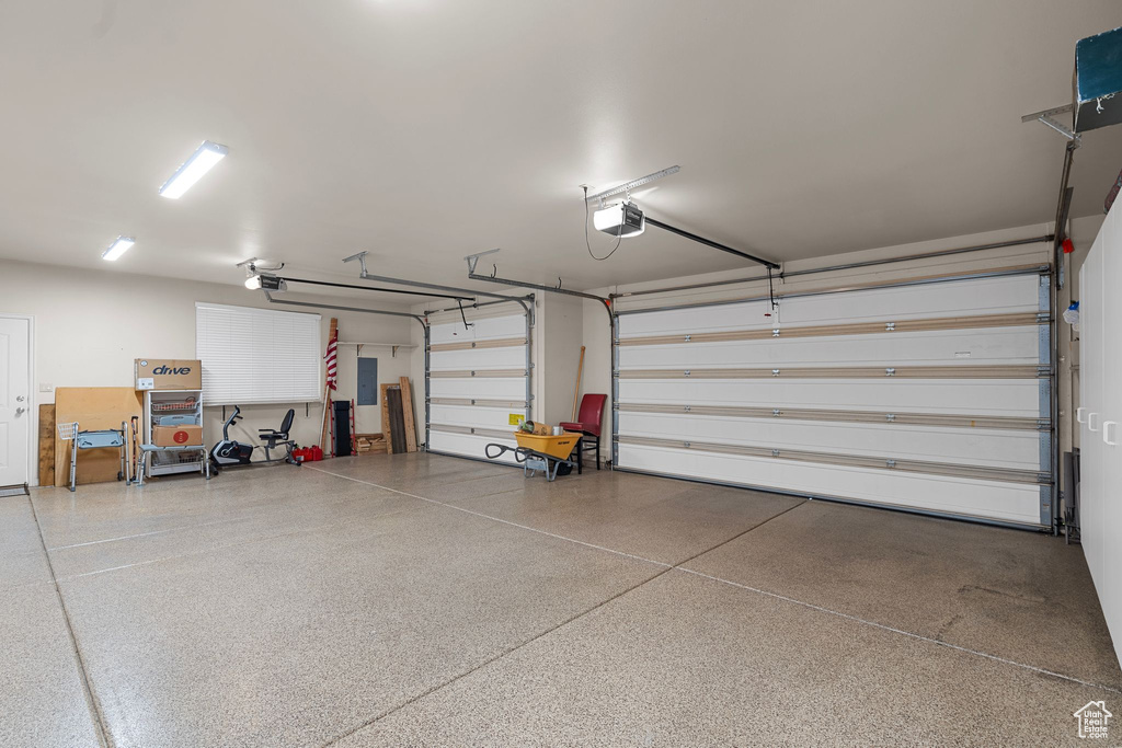 Garage featuring a garage door opener and electric panel