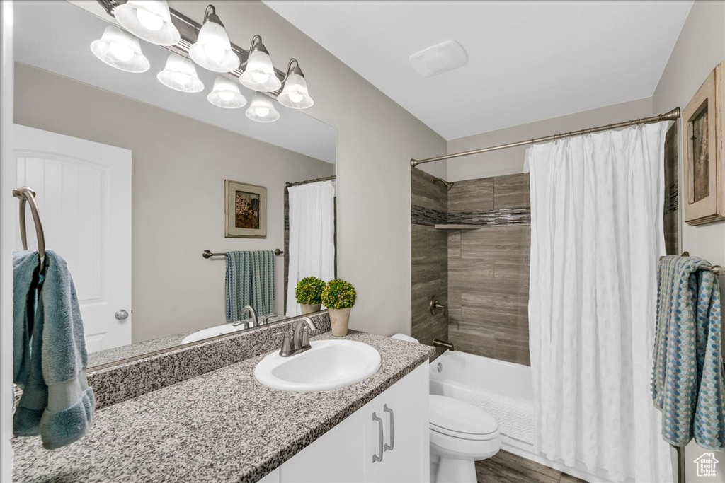 Full bathroom with shower / tub combo with curtain, vanity, and toilet