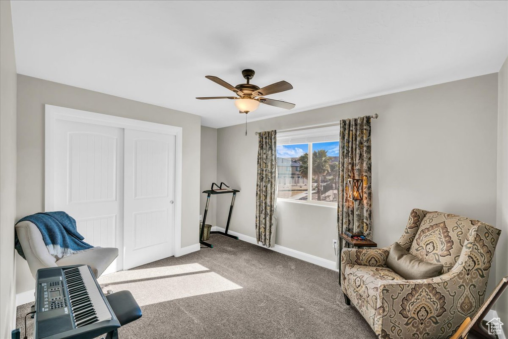 Sitting room featuring ceiling fan and carpet flooring