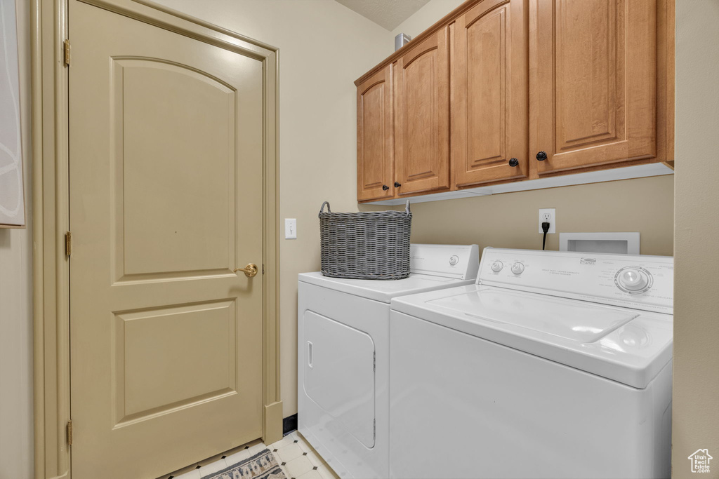 Laundry room featuring cabinets and washer and dryer