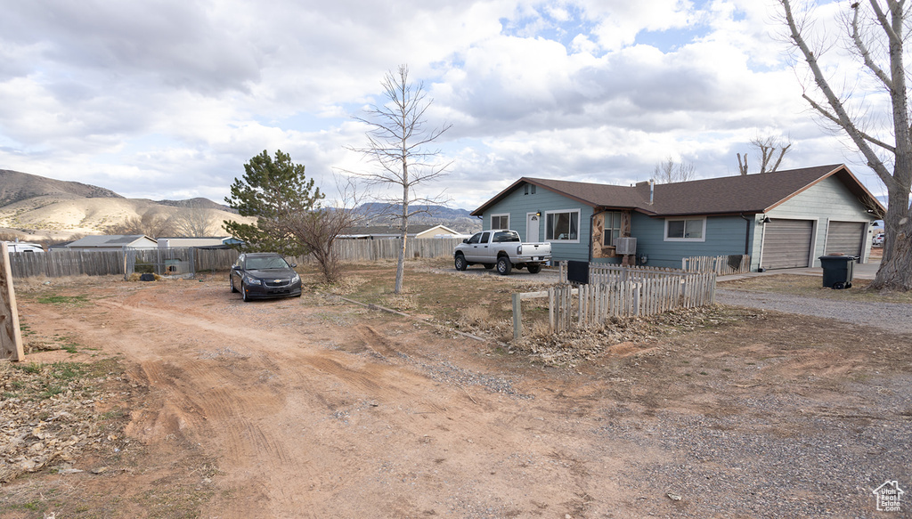 View of front of house with a garage and a mountain view