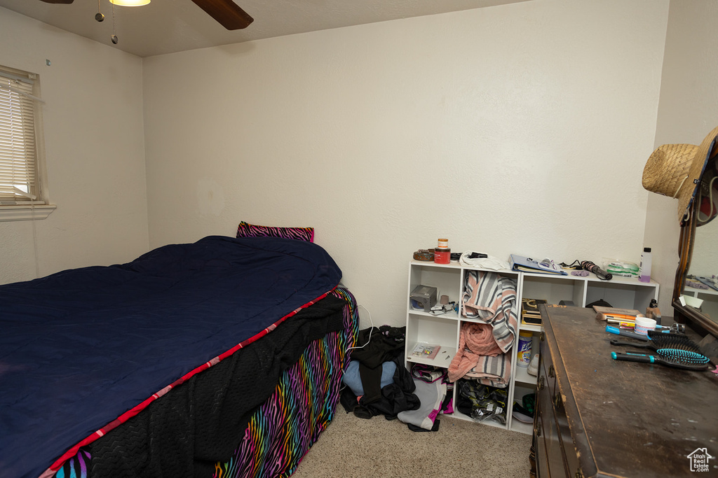 Carpeted bedroom featuring ceiling fan