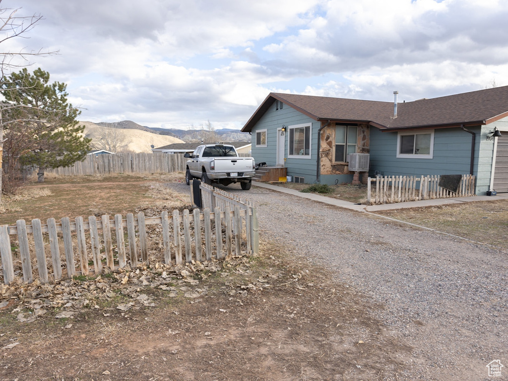 View of front of house featuring cooling unit, a mountain view, and a garage