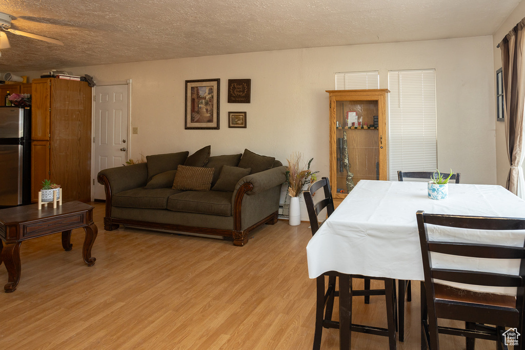 Dining room featuring ceiling fan, a textured ceiling, and light wood-type flooring