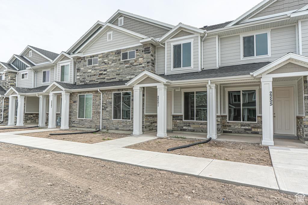 View of property featuring a porch and stone siding