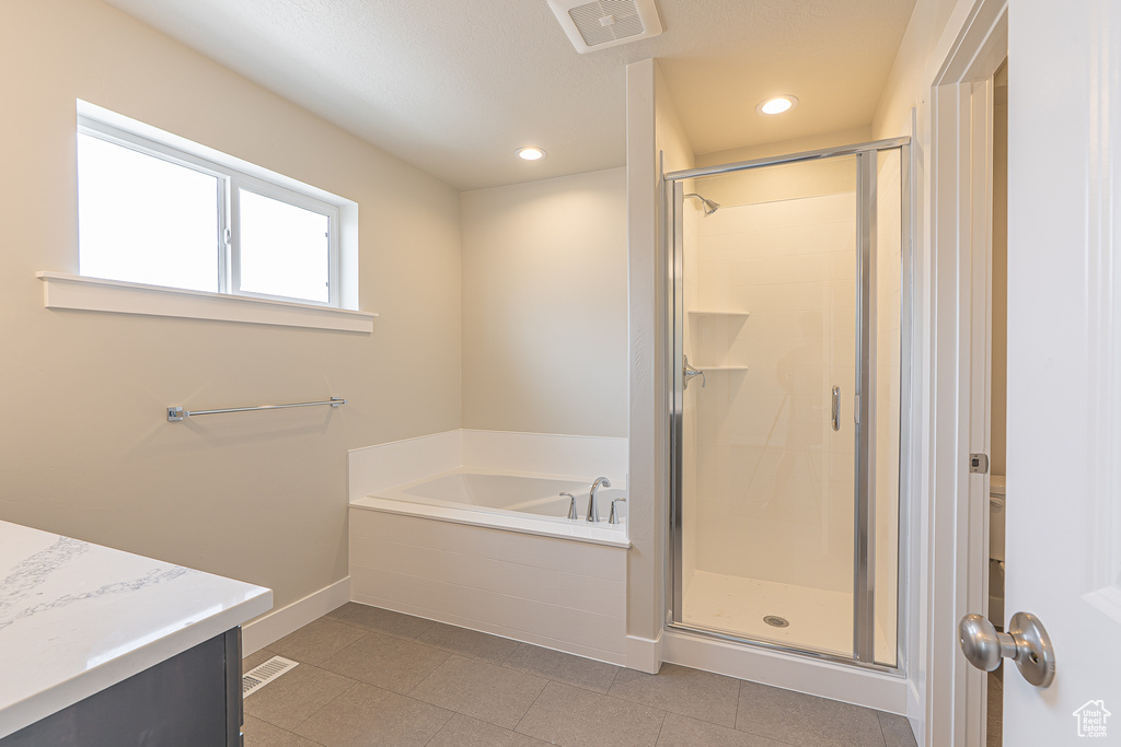 Full bath with baseboards, visible vents, a garden tub, and a stall shower