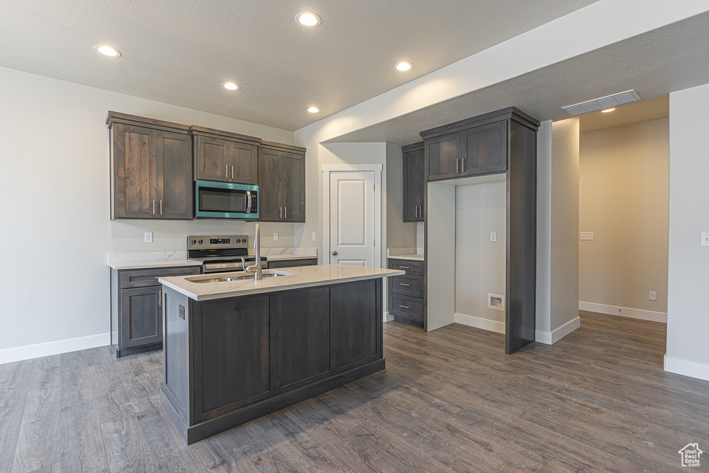 Kitchen featuring visible vents, light countertops, a sink, dark wood finished floors, and stainless steel appliances