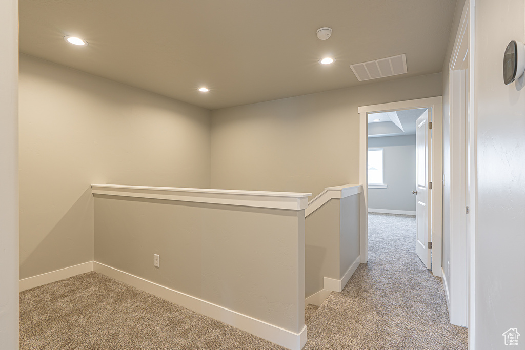 Hall with recessed lighting, baseboards, visible vents, and light carpet