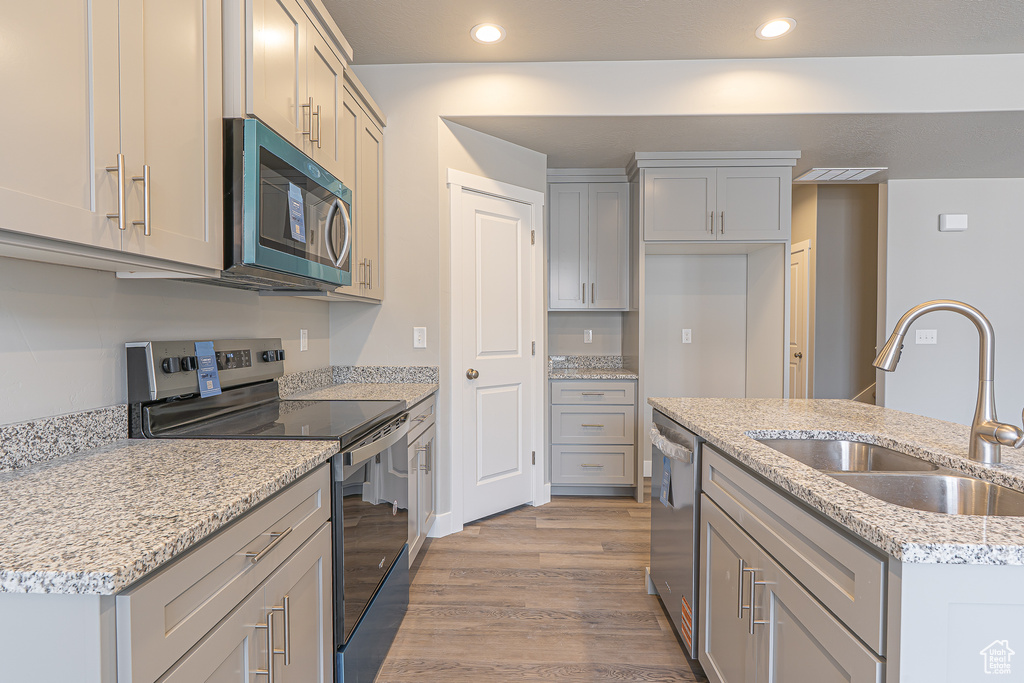 Kitchen featuring a sink, appliances with stainless steel finishes, recessed lighting, and light wood-type flooring