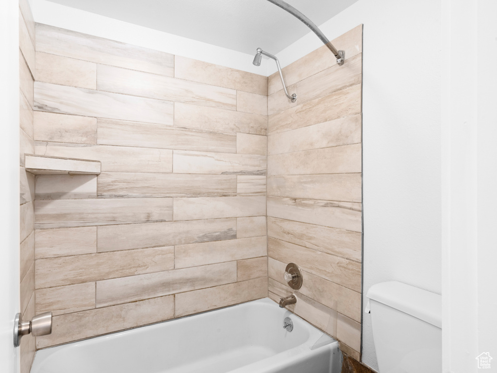 Bathroom with toilet and tiled shower / bath combo