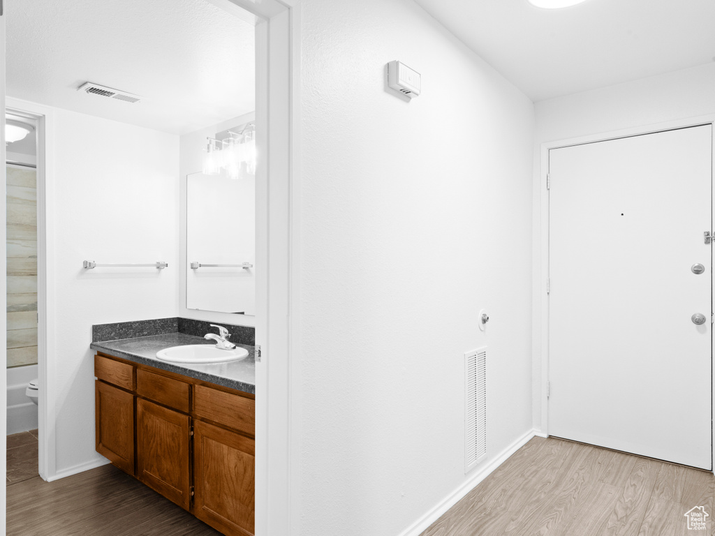 Bathroom with vanity, hardwood / wood-style flooring, and toilet