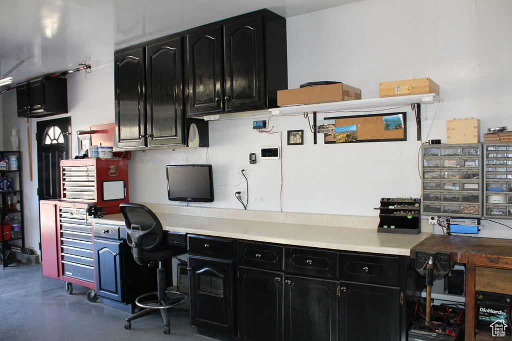 Office featuring built in desk and concrete floors