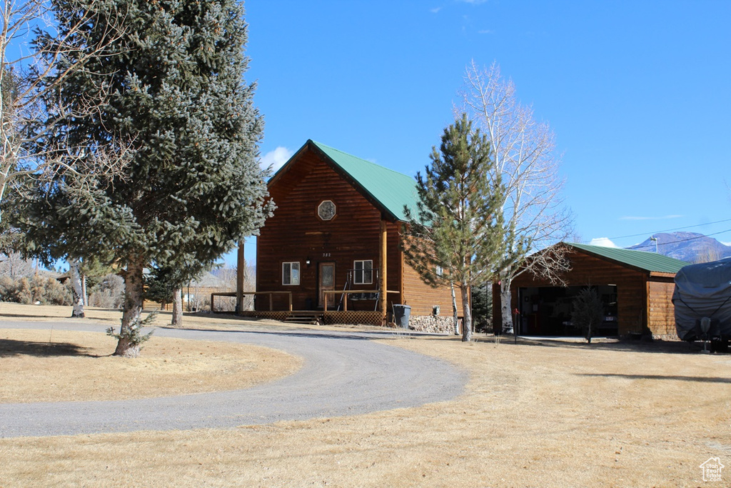 Log cabin featuring a garage and an outdoor structure