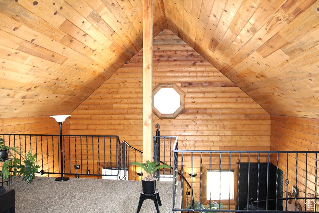 Interior space featuring wood ceiling, vaulted ceiling, and carpet