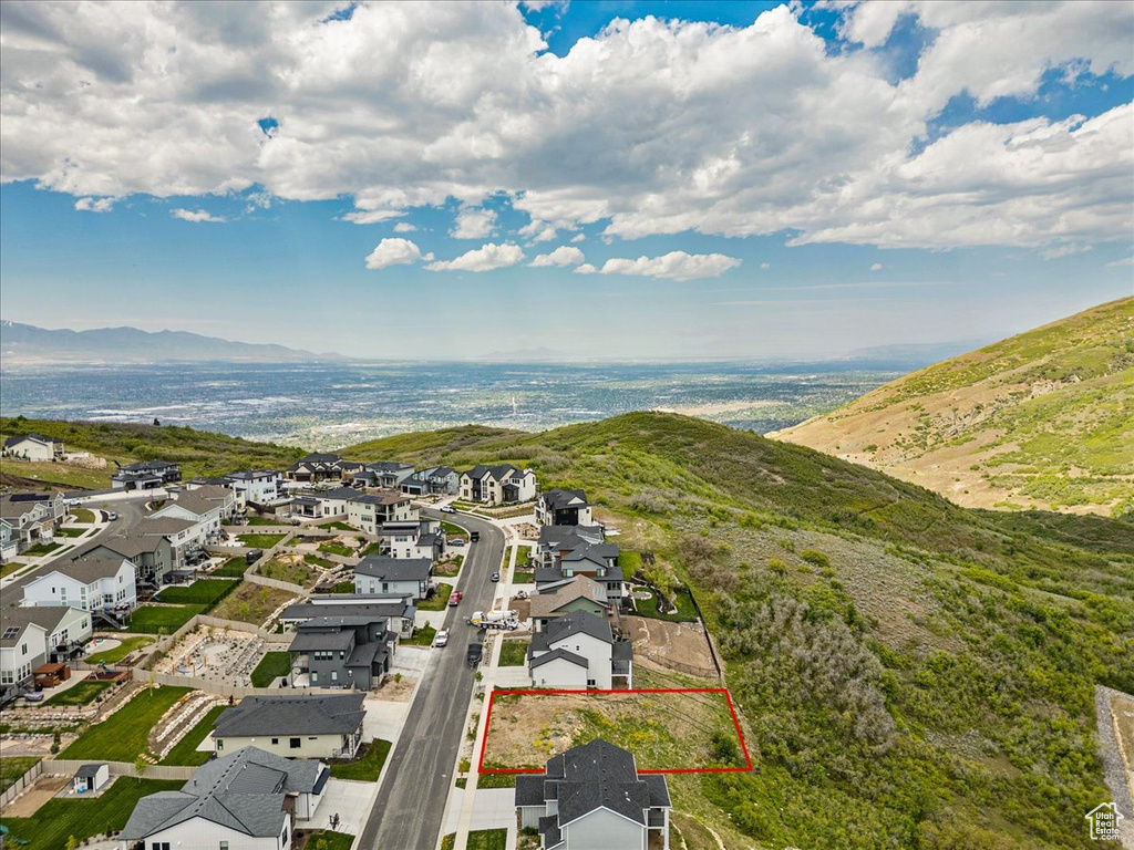Aerial perspective of suburban area with property parcel outlined and a mountain backdrop