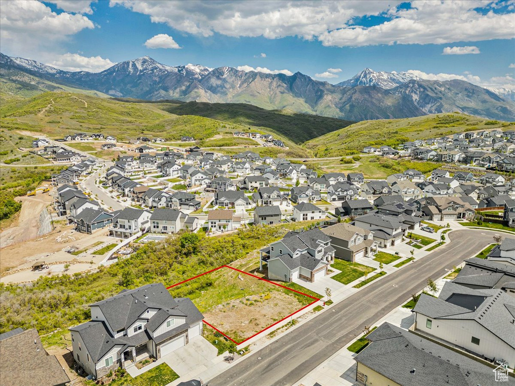 Aerial view of residential area featuring property boundaries highlighted and mountains
