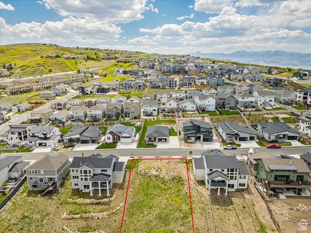 Aerial perspective of suburban area featuring a mountain backdrop and property parcel outlined