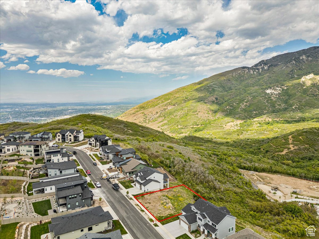 Aerial view of residential area with property boundaries highlighted and a mountain backdrop