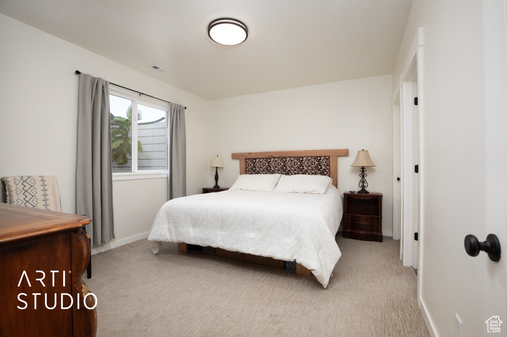 Bedroom featuring light carpet