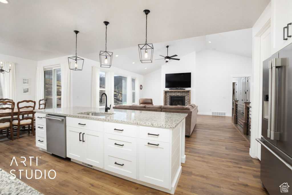 Kitchen featuring white cabinetry, sink, an island with sink, and appliances with stainless steel finishes