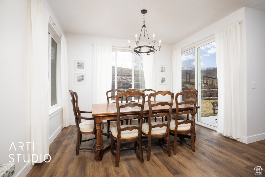 Dining room with plenty of natural light, dark hardwood / wood-style flooring, and a notable chandelier