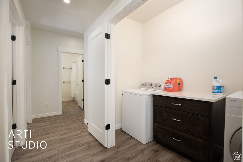 Laundry area with washer / dryer and light wood-type flooring