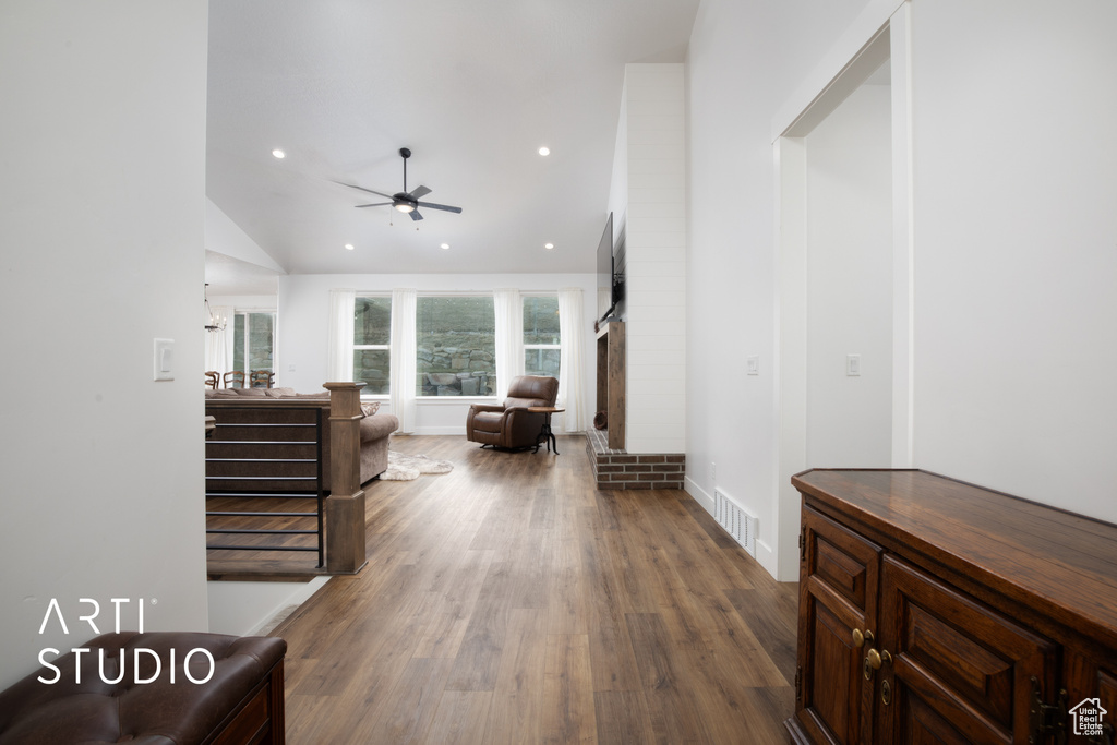 Living room with wood-type flooring, high vaulted ceiling, and ceiling fan
