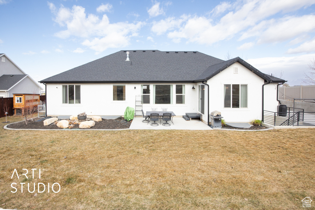 Rear view of property with a patio area and a lawn