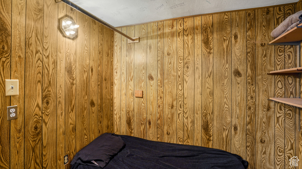 Bedroom featuring wood walls