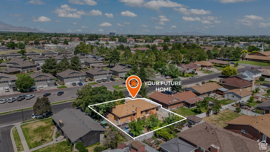 Aerial perspective of suburban area with property parcel outlined and a mountainous background