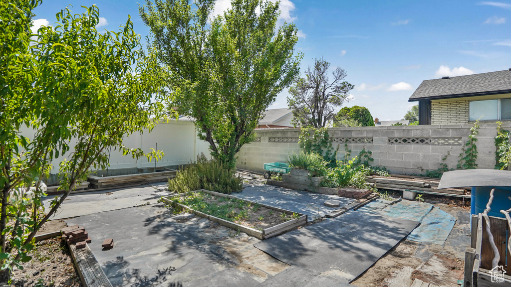 Fenced backyard with a garden and a patio area