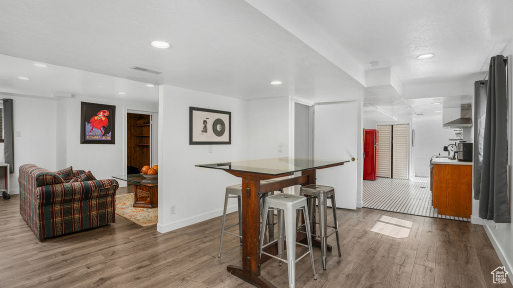 Dining area with wood finished floors and recessed lighting
