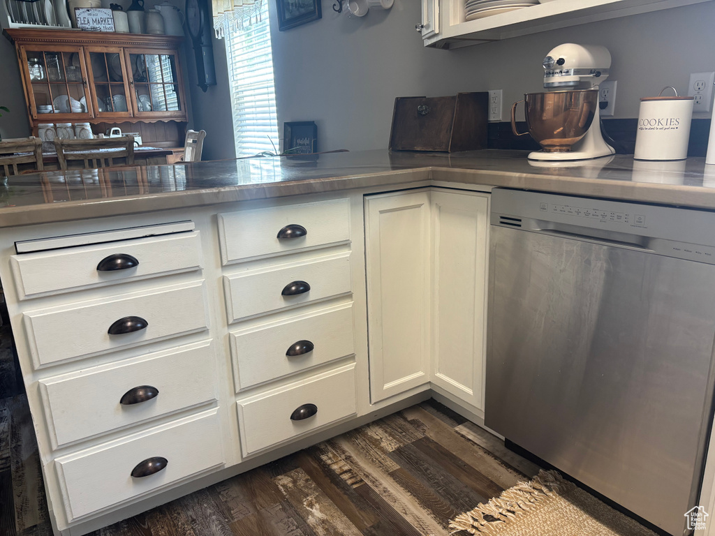 Kitchen with dishwasher, white cabinets, dark wood-style floors, and dark countertops