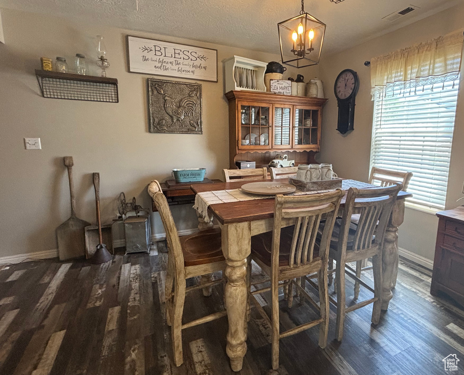 Dining space featuring wood finished floors, a chandelier, and baseboards